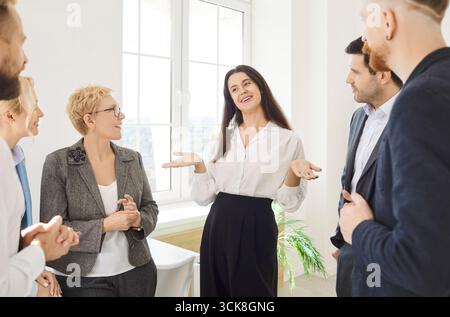 Business colleagues is gathered in modern office, engaged in lively and casual conversation Stock Photo