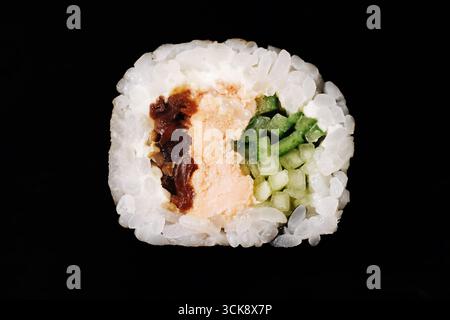 Sushi roll closeup with rice cucumber salmon and vegetables. Traditional Japanese cuisine on black background. Fresh seafood meal for healthy diet. Stock Photo
