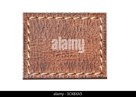Brown leather patch closeup. Rectangular label with stitching detail. Fashion accessory background. Natural leather texture isolated. Stock Photo