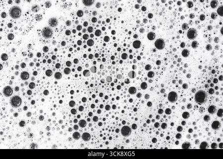 Foam with black bubbles closeup. Soap foam texture background. Water bubbles detail macro. Abstract cleaning concept. Stock Photo