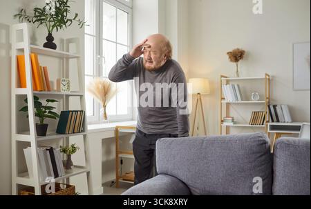 Sad Elderly Man Suffering From Headache At Home Stock Photo