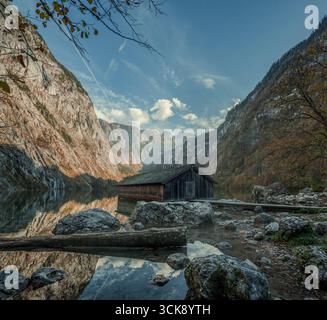Scenic view of a rustic wooden boathouse and dock on the emerald waters ...