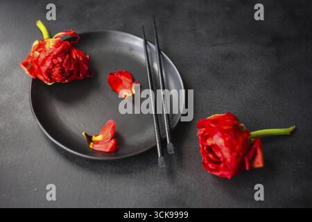Summer table setting decorated with Red Princess tulips on rustic background Stock Photo