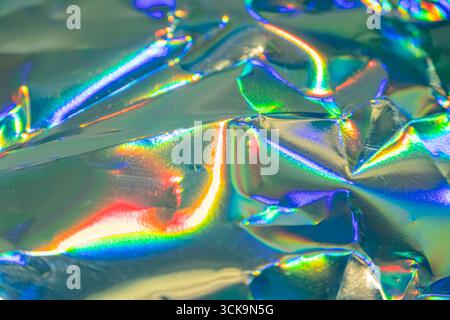 Image depicts a close-up of iridescent, metallic material with various color reflections, suitable for fashion, jewelry, or decoration Its well-lit an Stock Photo