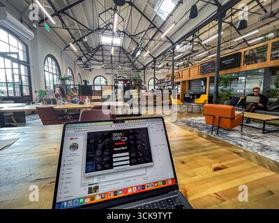 Douglas, Isle of Man 08,05,2023 Laptop is open on a wooden table in a large room with a view of a ceiling. The laptop is displaying a video game calle Stock Photo