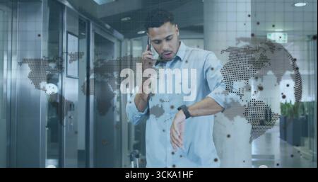 Businessman checking smartwatch calling smartphone and holding suitcase at airport with map overlay Stock Photo