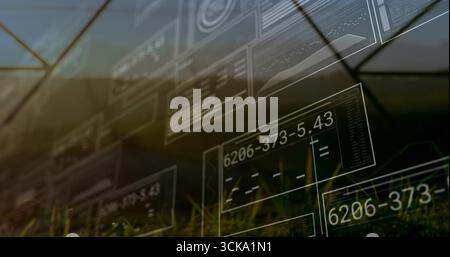 Floating translucent panels displaying numeric codes, charts and code blocks over grassy field Stock Photo
