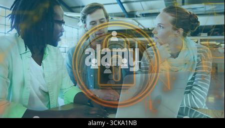 Three professionals analyzing holographic padlock graphic on laptop in open office, security focus Stock Photo