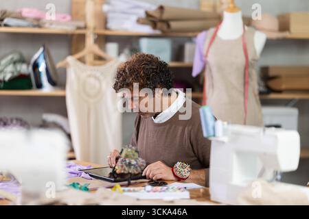 Man tailor makes pattern using tablet Stock Photo