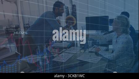 Shaking hands between two colleagues around glass table at modern office with laptops and charts Stock Photo