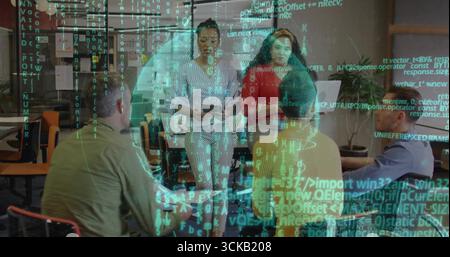 Collaborating team of five in business attire gathering around table in office with laptop tablet Stock Photo