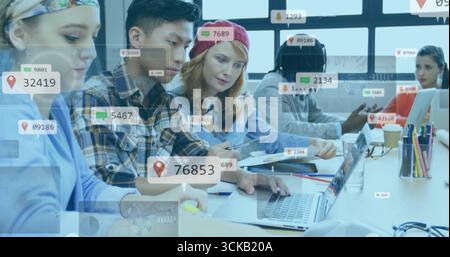 Collaborating team of five analyzing data on laptops in office, with notes, coffee and digital tags Stock Photo