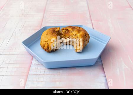 Hazelnut cookies with toasted hazelnut pieces   in the center, filled and topped with more chopped hazelnuts Stock Photo