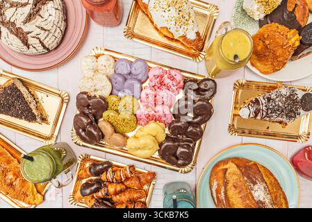 An aerial view of a colorful selection of cupcakes with vibrantly colored frosting, artisan chocolates, and cookies decorated with royal icing Stock Photo