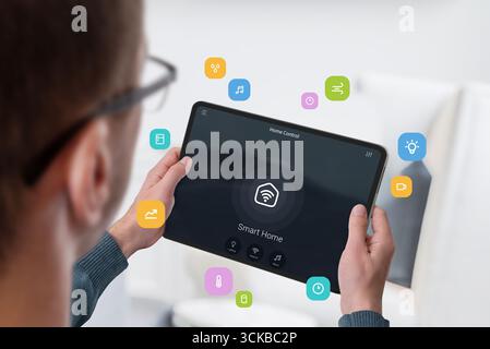 Close-up of person adjusting smart home appliances through digital tablet application Stock Photo