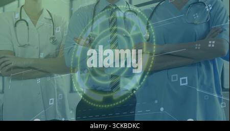Standing medical team in uniforms, crossing arms at clinic, with stethoscopes and digital overlay. Healthcare, teamwork, technology, professionalism, Stock Photo