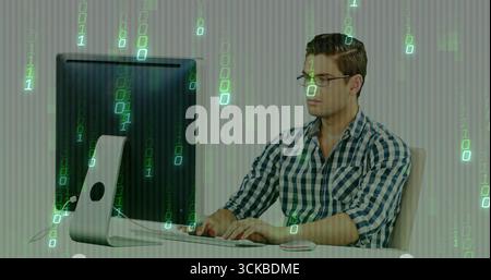 Typing man wearing checkered shirt using computer setup at office desk with binary overlay. Technology, programming, innovation, digital, workspace, m Stock Photo