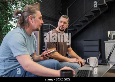 Group of professional it programmers collaborating in a modern office setting. They display focus and enthusiasm, creating a dynamic work environment Stock Photo