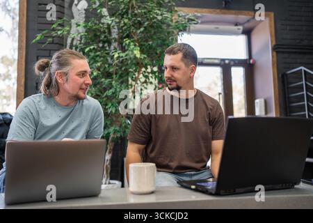 Team of programmers coding on laptops working at creative office Stock Photo