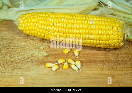 Tutu of corn peeled on a wooden board with grains. One Stock Photo
