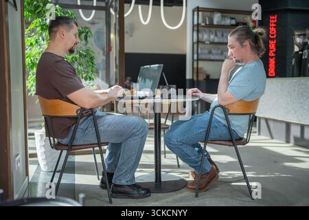 Two It Software engineers working on project and programming in coffee shop. Business people concept. Stock Photo