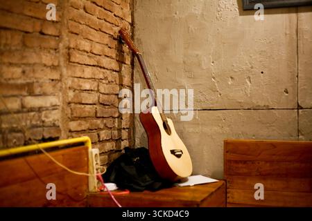 acoustic guitar leaning against the corner of the wall Stock Photo