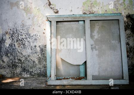 old window frame glass broken leaning on the wall Stock Photo
