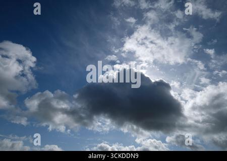 bright sunshine behind clouds on blue sky background Stock Photo