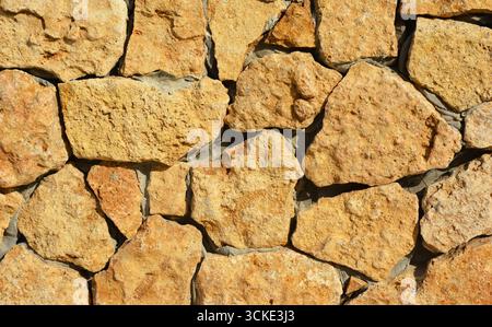 Wall made of wild stone and mortar with copy space. Stock Photo