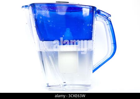 Household water filter pitcher with replaceable cartridge and clean filtered water inside isolated on white background, close up Stock Photo