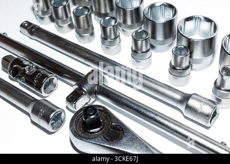 A set of new tools on a white background. Set of adjustable wrenches with handle holder, adapters and extensions and detachable sockets. Stock Photo