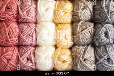 Clews of threads for knitting of different colors are stacked on the shelves, close-up. Stock Photo
