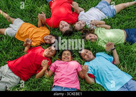 Miami Florida,Non Violence Project USA,teaching student students non violent behavior,boys boy girl girls smiles smiling,hold holding hand hands circ Stock Photo