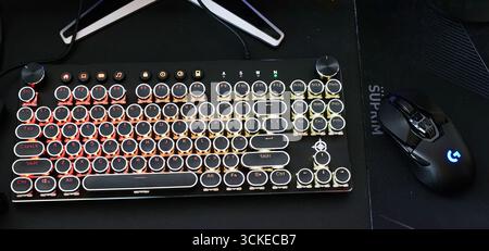 Elegant mechanical keyboard and gaming mouse setup on a sleek surface with ambient lighting in a modern workspace at night Stock Photo