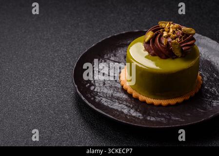 Pistachio cake or tart topped with green mousse with nuts and fruit filling. Pistachio pie as a food background for your design Stock Photo