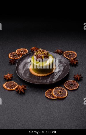 Pistachio cake or tart topped with green mousse with nuts and fruit filling. Pistachio pie as a food background for your design Stock Photo