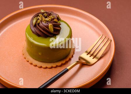 Pistachio cake or tart topped with green mousse with nuts and fruit filling. Pistachio pie as a food background for your design Stock Photo