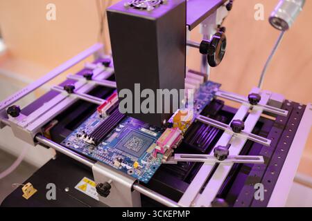 Detailed assembly of an intricate circuit board takes place in a high-tech laboratory. Precision equipment ensures flawless connections and quality. Stock Photo