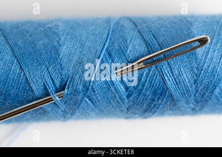 Sewing threads and needle on white background. Close up Stock Photo