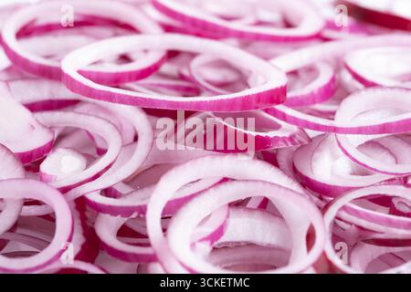 Red onion sliced into salad rings on white background. Closeup Stock Photo