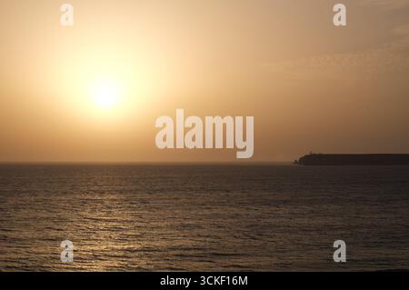 Sun setting over the Atlantic Ocean, seen from Cape St Vincent, Sagres, Vila do Bispo, Algarve, Portugal. Stock Photo