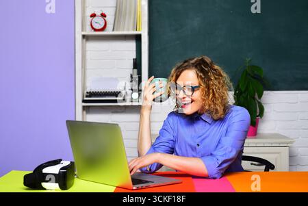 Student girl preparing for exam or test at university. Smiling school teacher or businesswoman working with laptop at workplace. Learning, education. Stock Photo