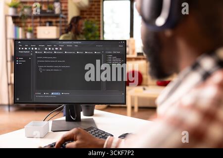 Closeup of african american freelance coder using desktop pc to write and review website code. Black tech entrepreneur working from home on computer, debugging programming language. Stock Photo