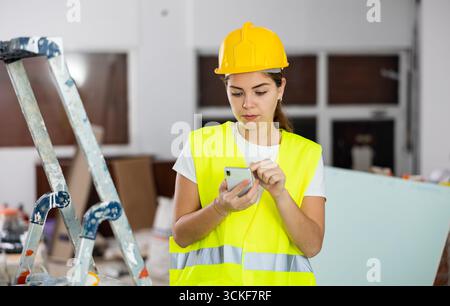 Young woman engineer using smartphone in construction site Stock Photo