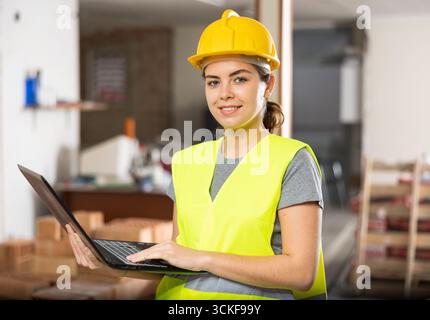 Female engineer using laptop in apartment Stock Photo