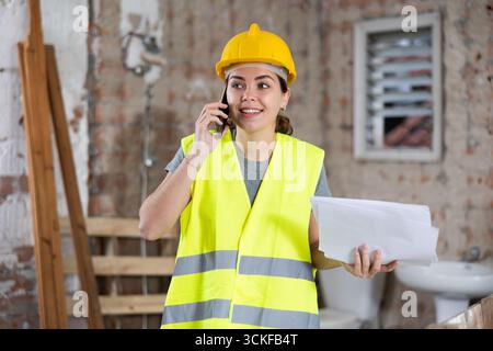 Young woman construction worker talking on phone Stock Photo