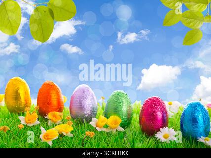 Easter eggs on a lawn with flowers in the garden, Composing Stock Photo