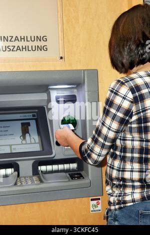 inserting an EC card into an ATM Stock Photo