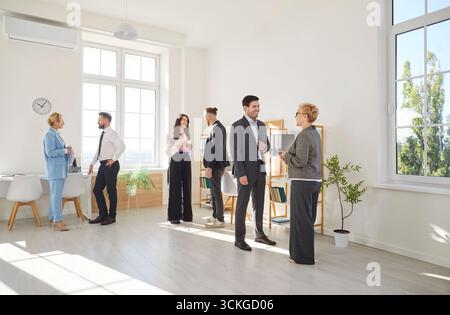 Diverse group of colleagues communicate and collaborate, creating friendly atmosphere in office. Stock Photo
