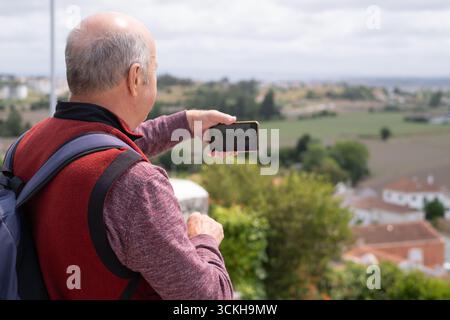 elderly man taking photos of views during vacation in Portugal Stock Photo